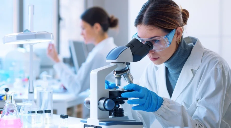 a scientist looking through a microscope