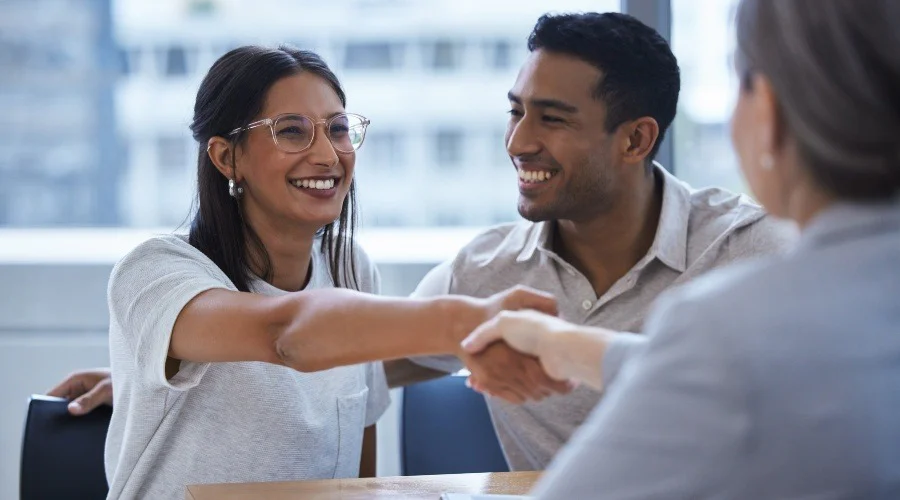 a couple shaking hands with a financial advisor