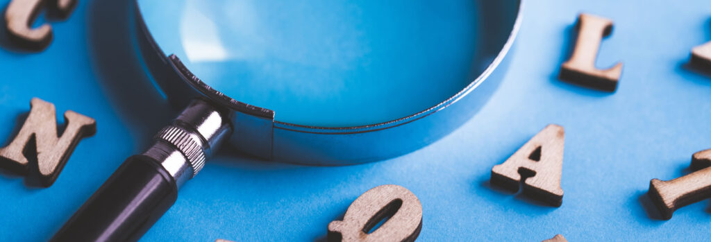 a magnifying glass and wooden letters