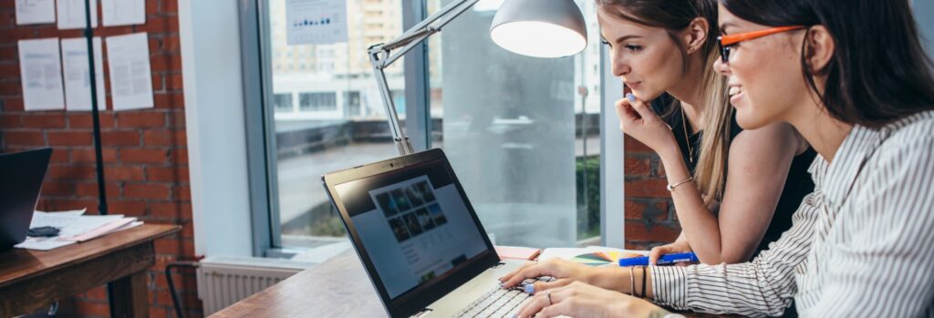 two women working on a laptop