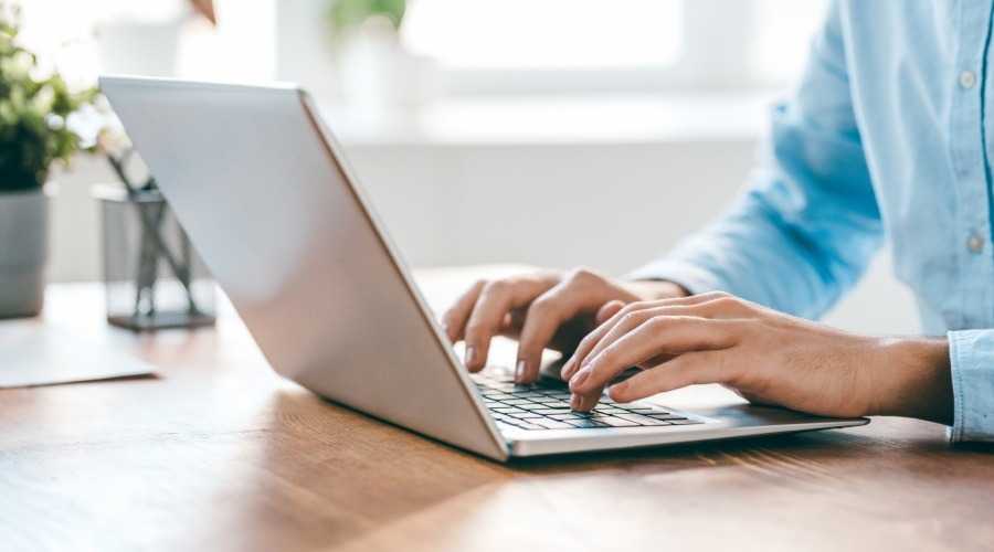 hands typing on a laptop