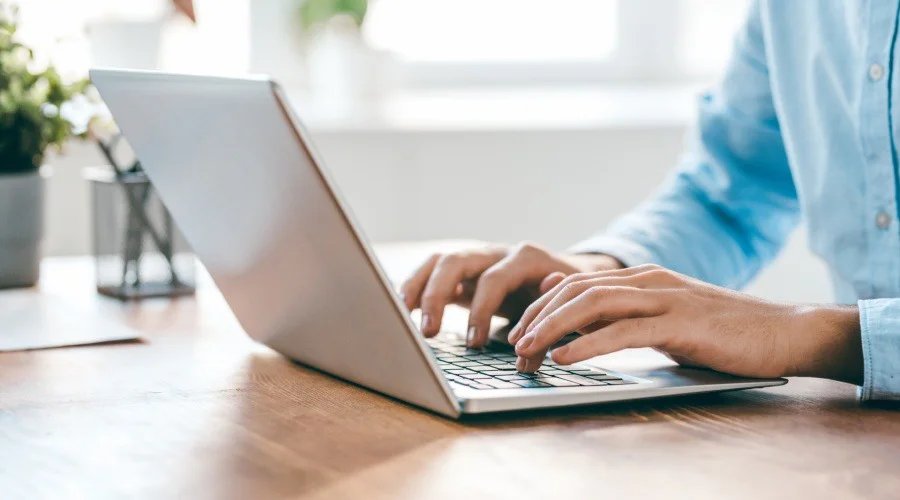 hands typing on a laptop