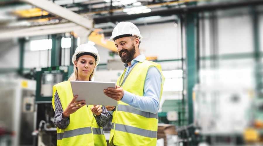 two people in high vis clothing in a factory
