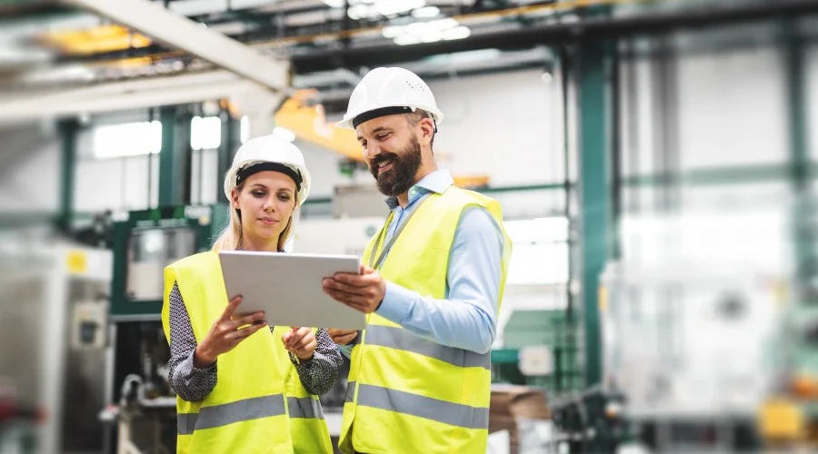 two people in high vis clothing in a factory