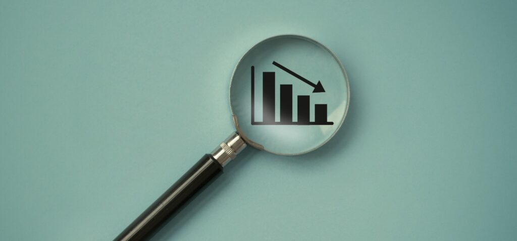 a magnifying glass over a graph showing a decline