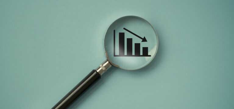 a magnifying glass over a graph showing a decline